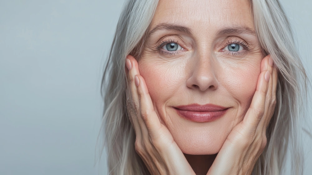 Mid Aged Woman Touching Face Gently in Sycamore, IL | Nuvo Aesthetics Clinic